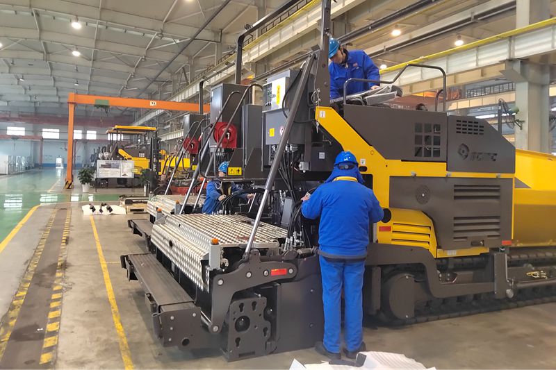 1、工人們抓緊時間總裝即將出口的瀝青混凝土攤鋪機.jpg